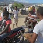 Three men organising a pig transport to the nearby market.